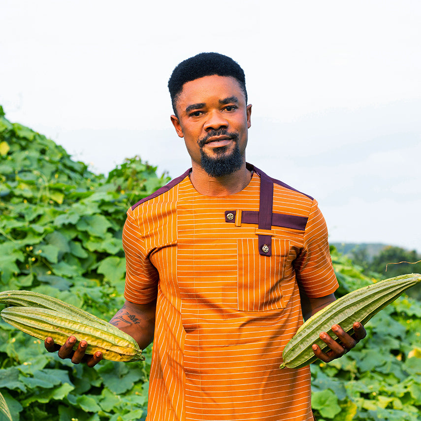 Baker Creek seed grower Solomon Amuzu holding a trio of Krobonko Luffa Gourds in Ghana.
