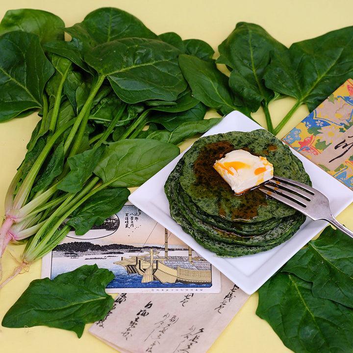 Jiromaru Spinach with spinach pancakes and fresh leaves on yellow background.