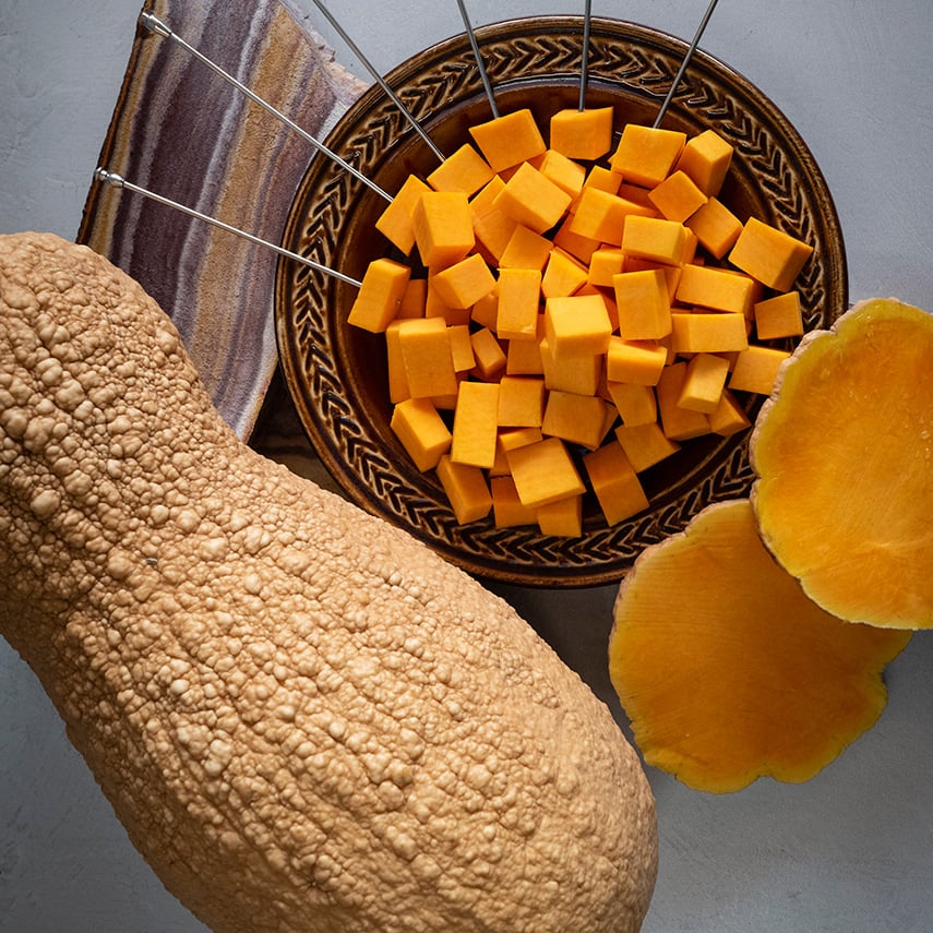 Butternut Rogosa Violina Gioia Winter Squash with chopped squash in a bowl.