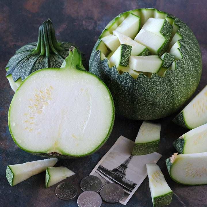 Cut and chopped Ronde De Nice Summer Squash with an image of the Eiffel Tower on dark background.