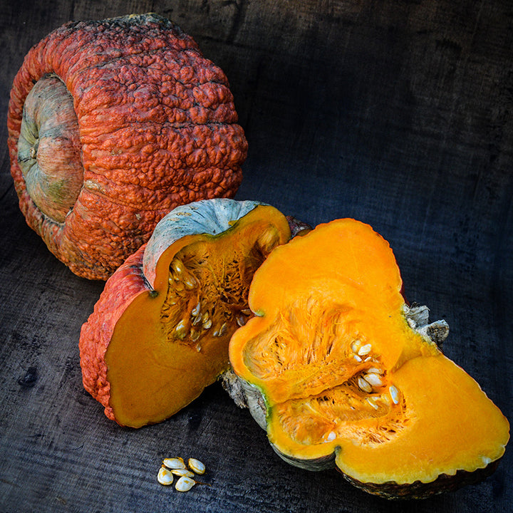 Whole and sliced Essex Hybrid Winter Squash on a wooden background.