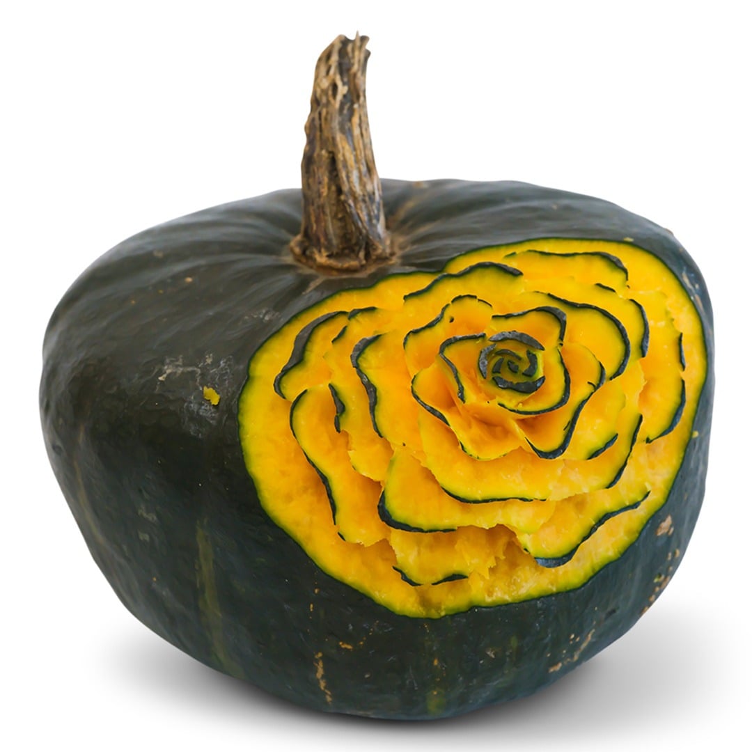 Buttercup winter squash with decorative carving on a white background