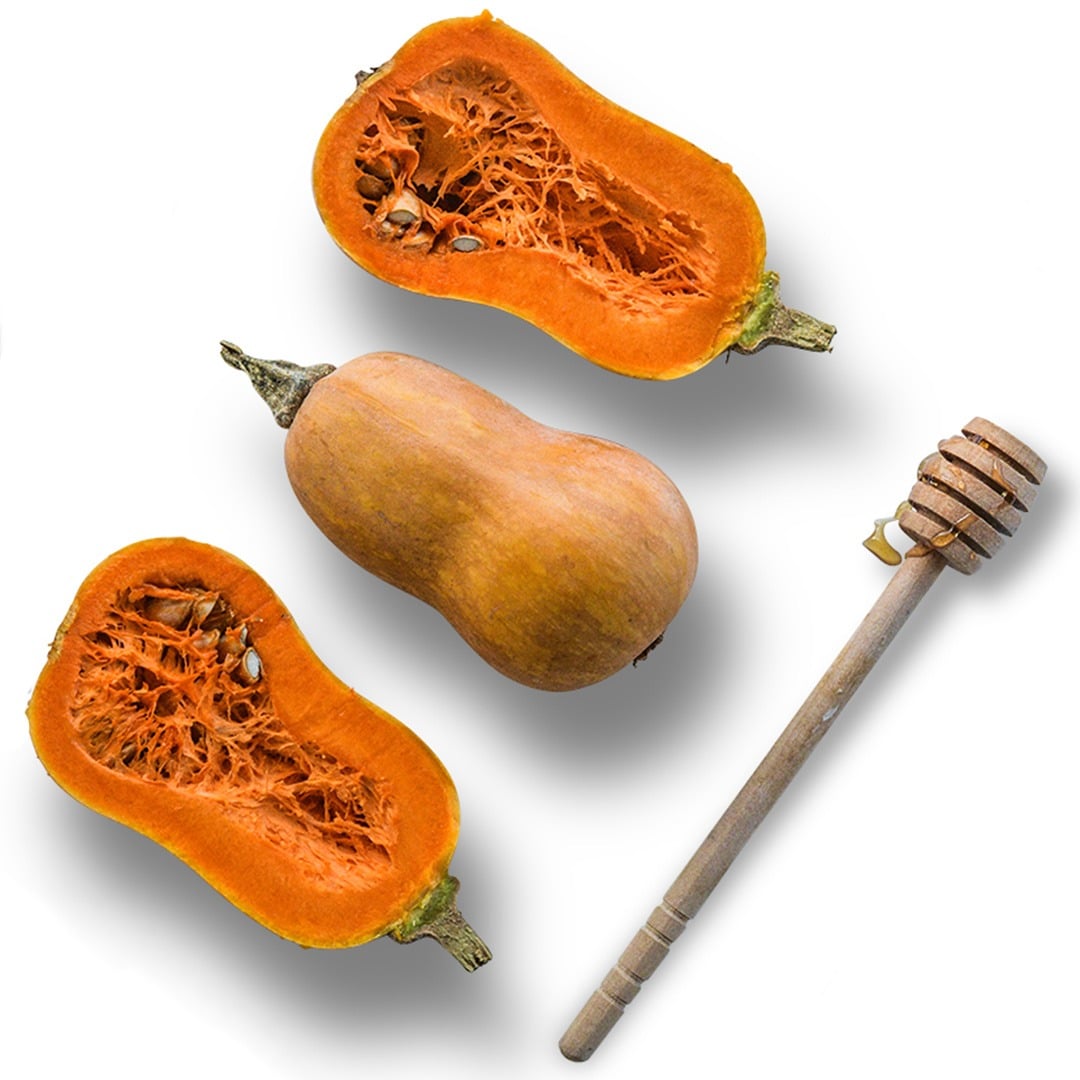 Whole and cut Honeynut Butternut Winter Squash with a honeycomb on a white background.