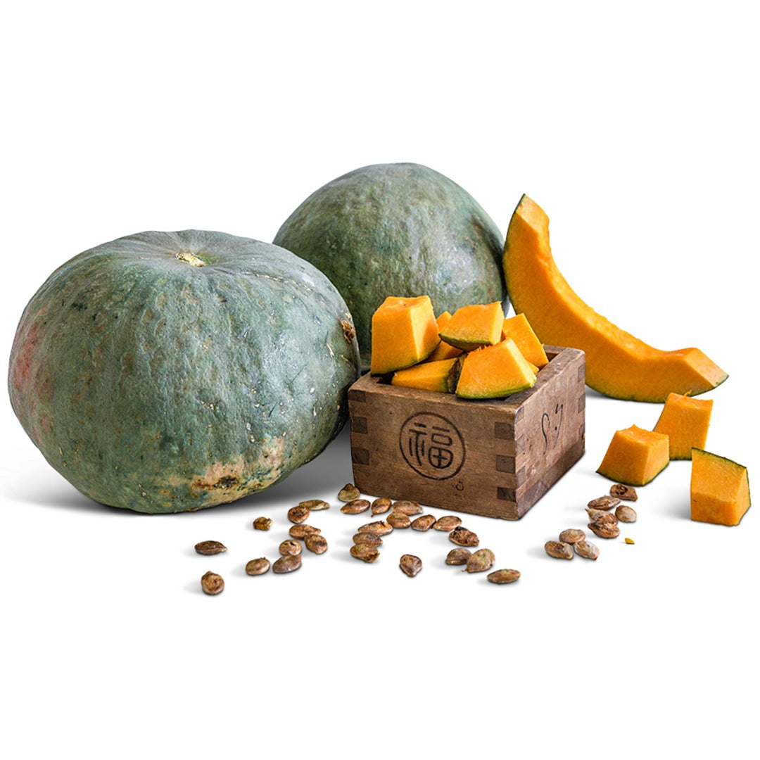 Whole and cut Tokyo Blue Winter Squash with seeds on a white background.