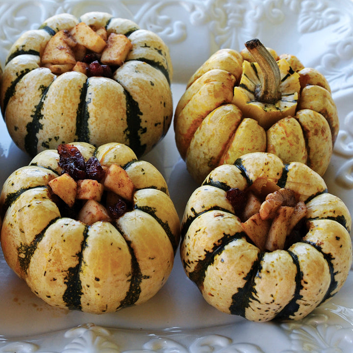 Stuffed Sweet Dumpling Winter Squash on a white plate.
