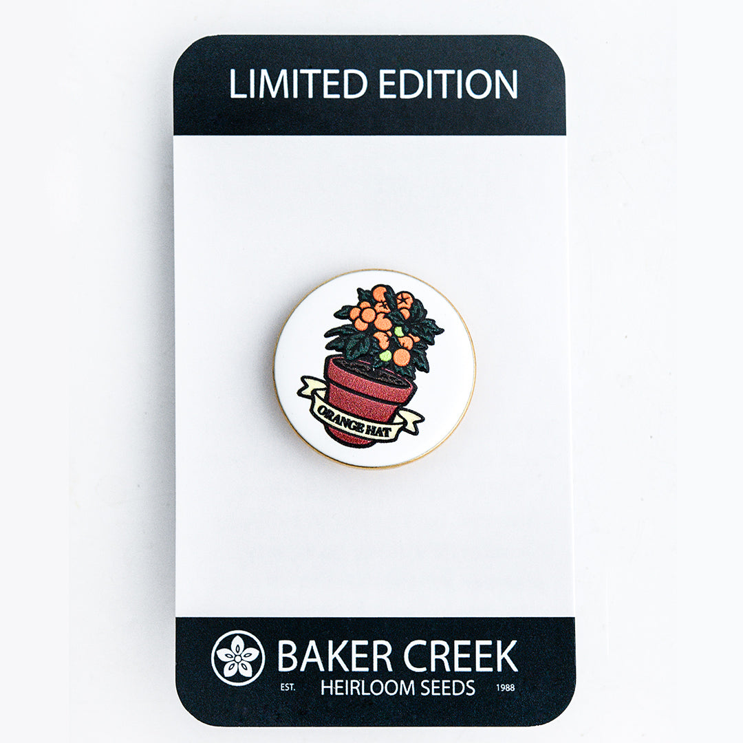 Orange Hat Tomato Limited Edition Pin with packaging on a white background.