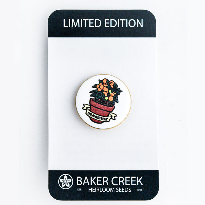 Orange Hat Tomato Limited Edition Pin with packaging on a white background.