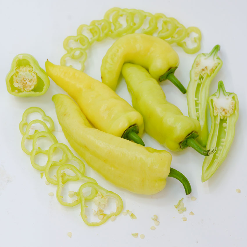 Banana Sweet Pepper with whole and sliced pieces on a white background.