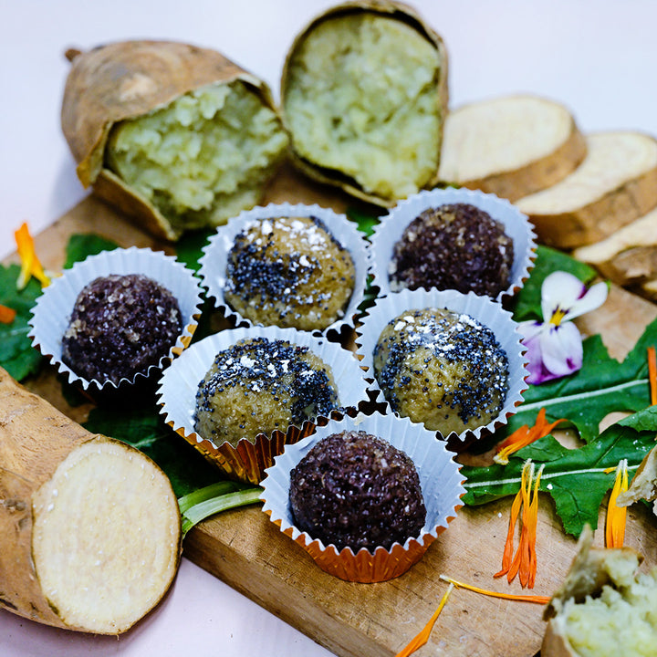 Jersey White Sweet Potato truffles with sweet potatoes on a cutting board.
