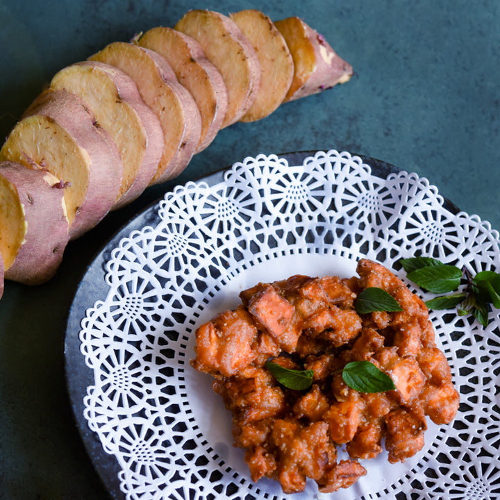 Sliced Korean Gold Sweet Potatoes with sweet potato fritters on a jade colored background.