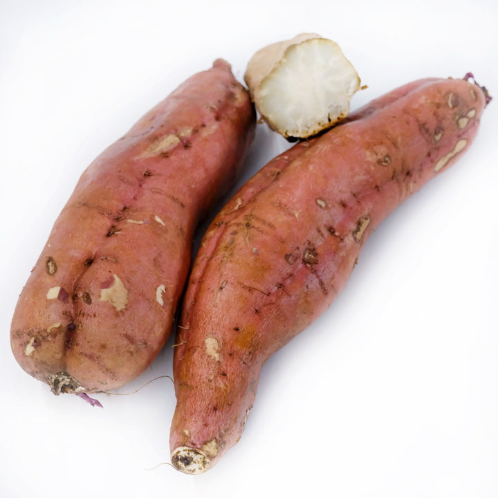 Cooked and raw Seon Mi Sweet Potatoes on a white background.