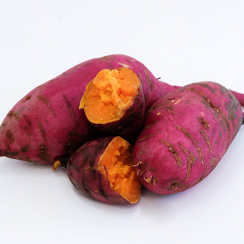 Raw and cooked Carogold Sweet Potatoes on a white background.