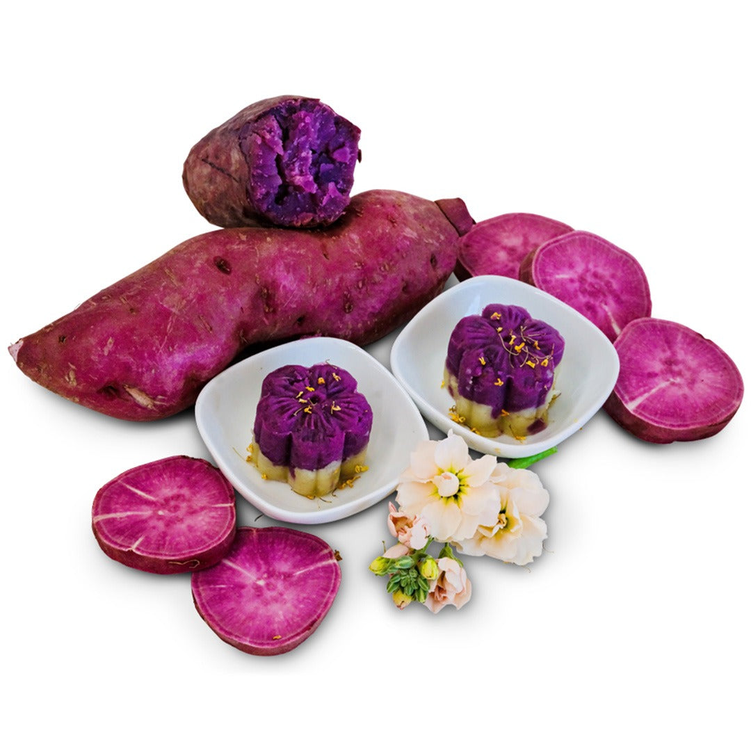 Whole and sliced Lilac Beauty Sweet Potatoes arranged on a white background.