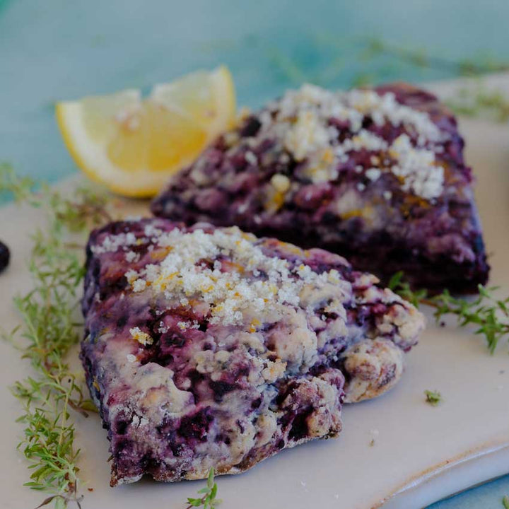Orangelo Thyme on a plate with 2 black raspberry scones.
