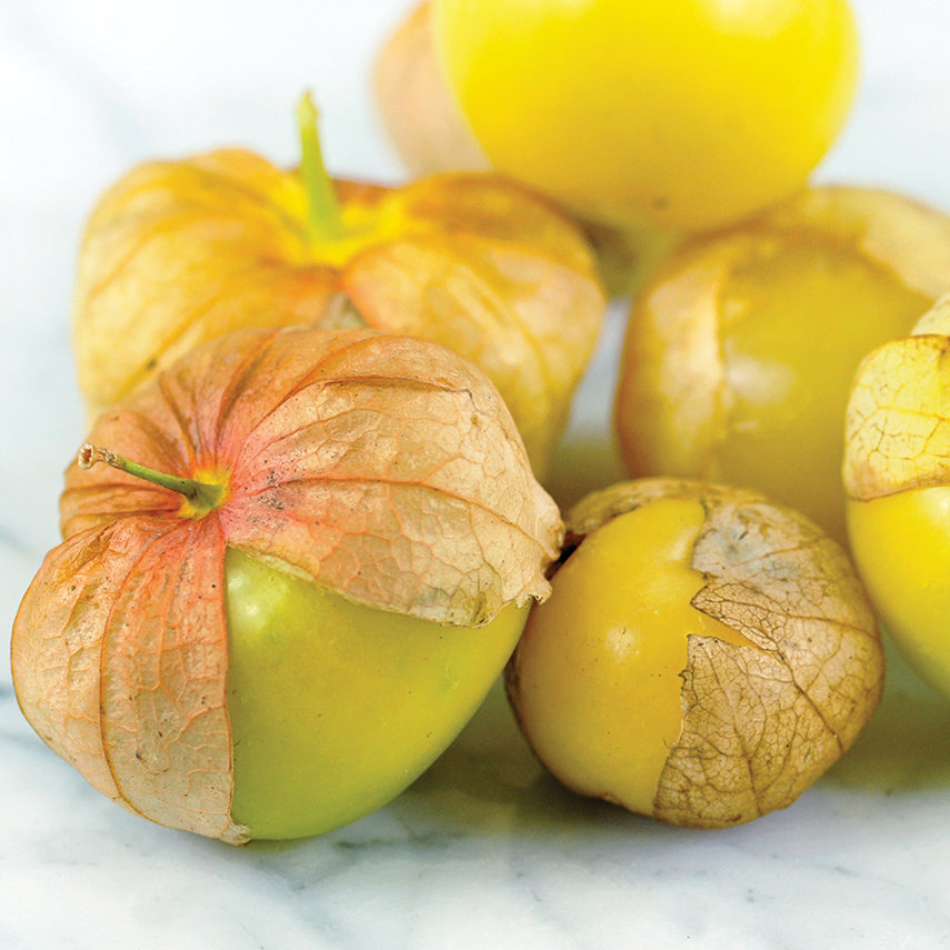 Close-up view of Amarylla Tomatillos on a white marble countertop.