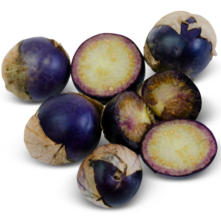 Pile of Purple Coban Tomatillos on a white background.
