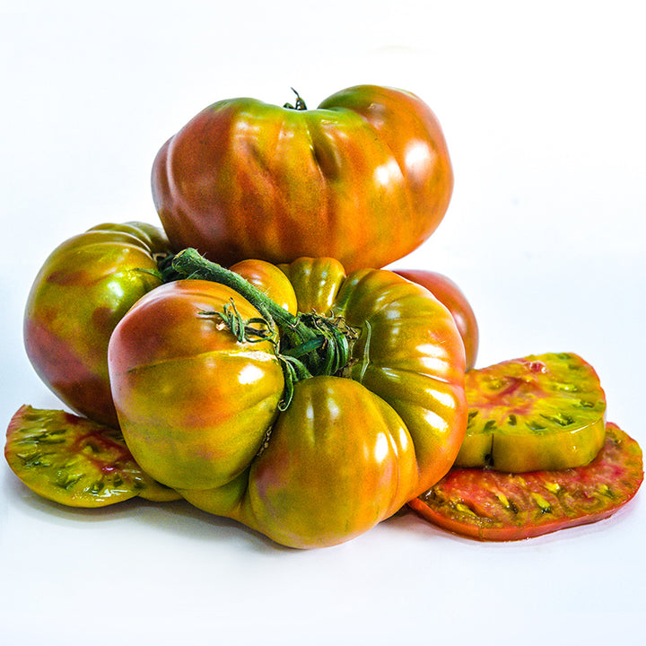 Large Ananas Noire or Black Pineapple Tomatoes with slices on a white background.