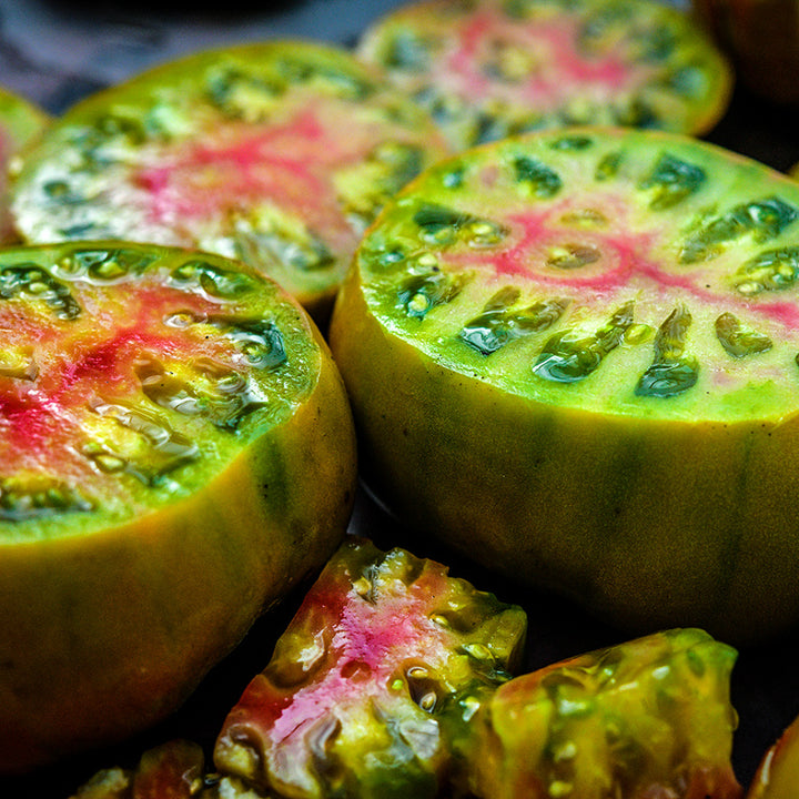 Close-up of colorful cut Ananas Noire or Black Pineapple Tomatoes slices.