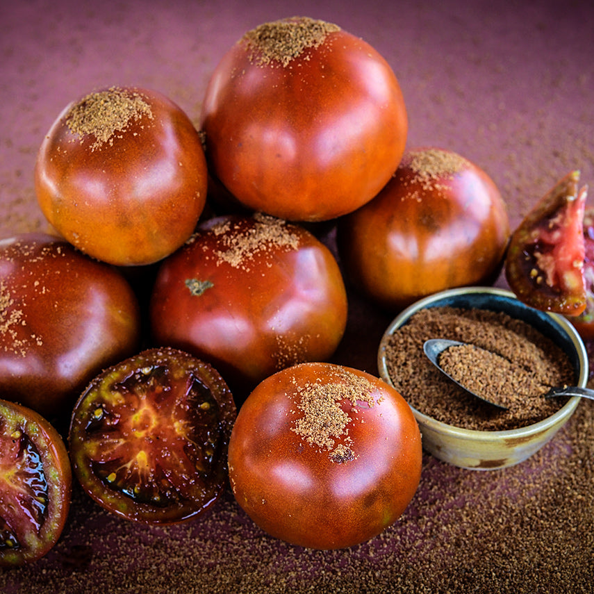 Brown Sugar Tomatoes with brown sugar sprinkled on a deep red background.