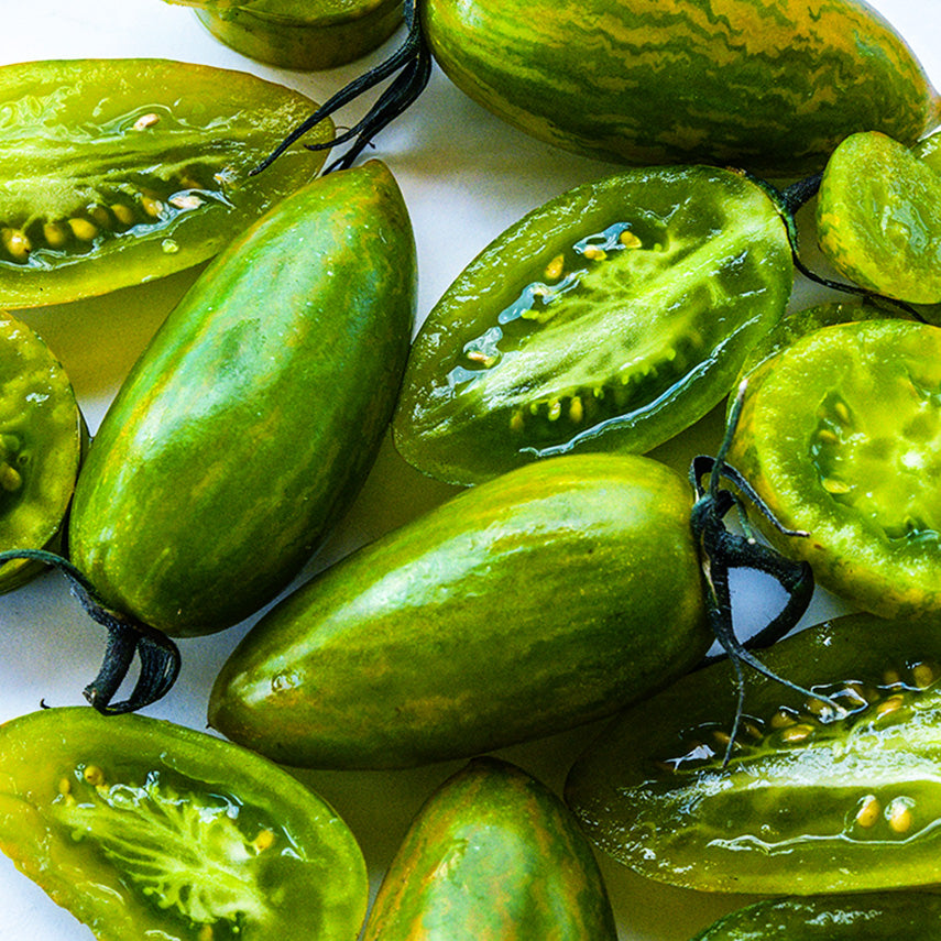 Close-up of juicy sliced and whole Green Tiger Tomatoes.