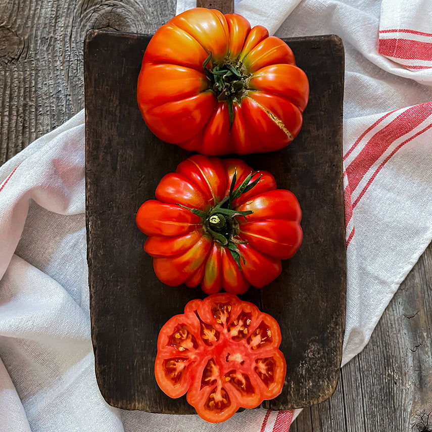 Cut and whole Mushroom Basket Tomatoes on a board with dish towel. Image by Lucy Hutchins.