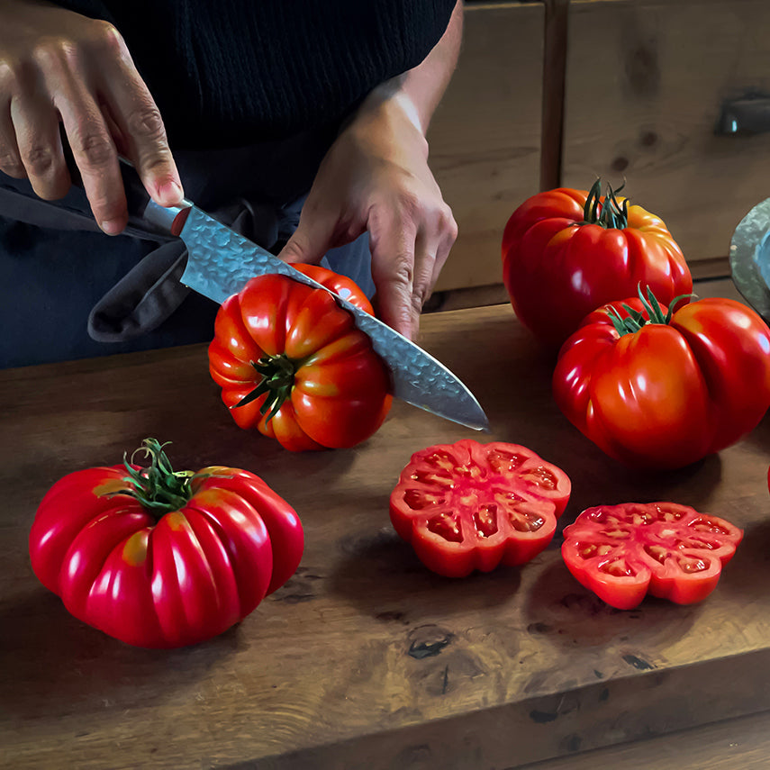 Woman cutting Mushroom Basket Tomatoes on wooden cutting board. Image by Lucy Hutchins.