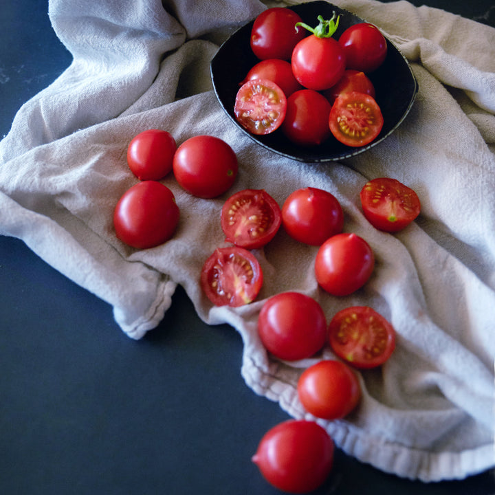 Riesentraube Tomatoes in a bowl and spilling out onto a dishcloth.