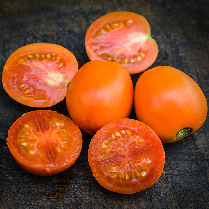 A macro close-up view of Auriga Tomatoes on wood cutting board.