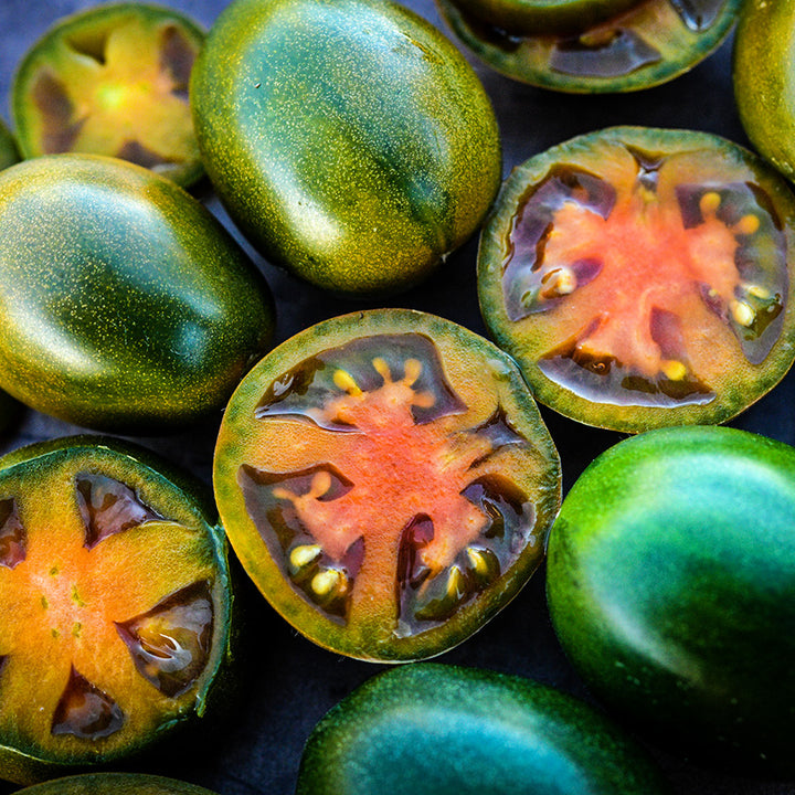 Close-up macro of sliced and whole Evil Olive Tomatoes.