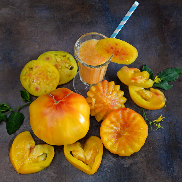 Creatively carved and sliced Pineapple Tomatoes with juice on a dark background.