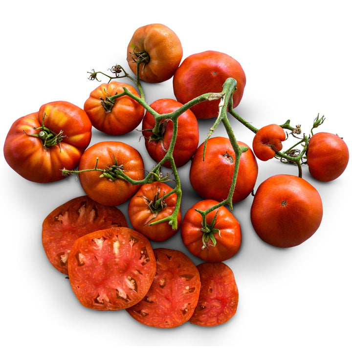 Cut and whole Classic Beefsteak Tomatoes on white background.