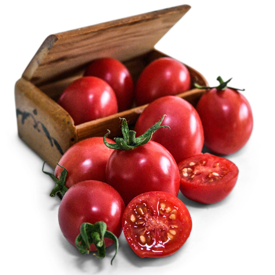 Bunch of German Lunchbox tomatoes in a wooden box and surround on a white background.