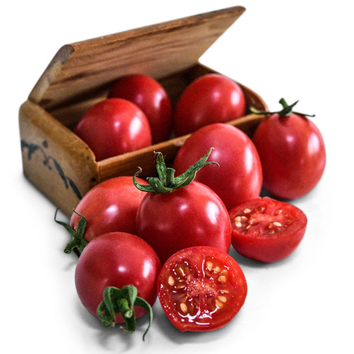 Bunch of German Lunchbox tomatoes in a wooden box and surround on a white background.