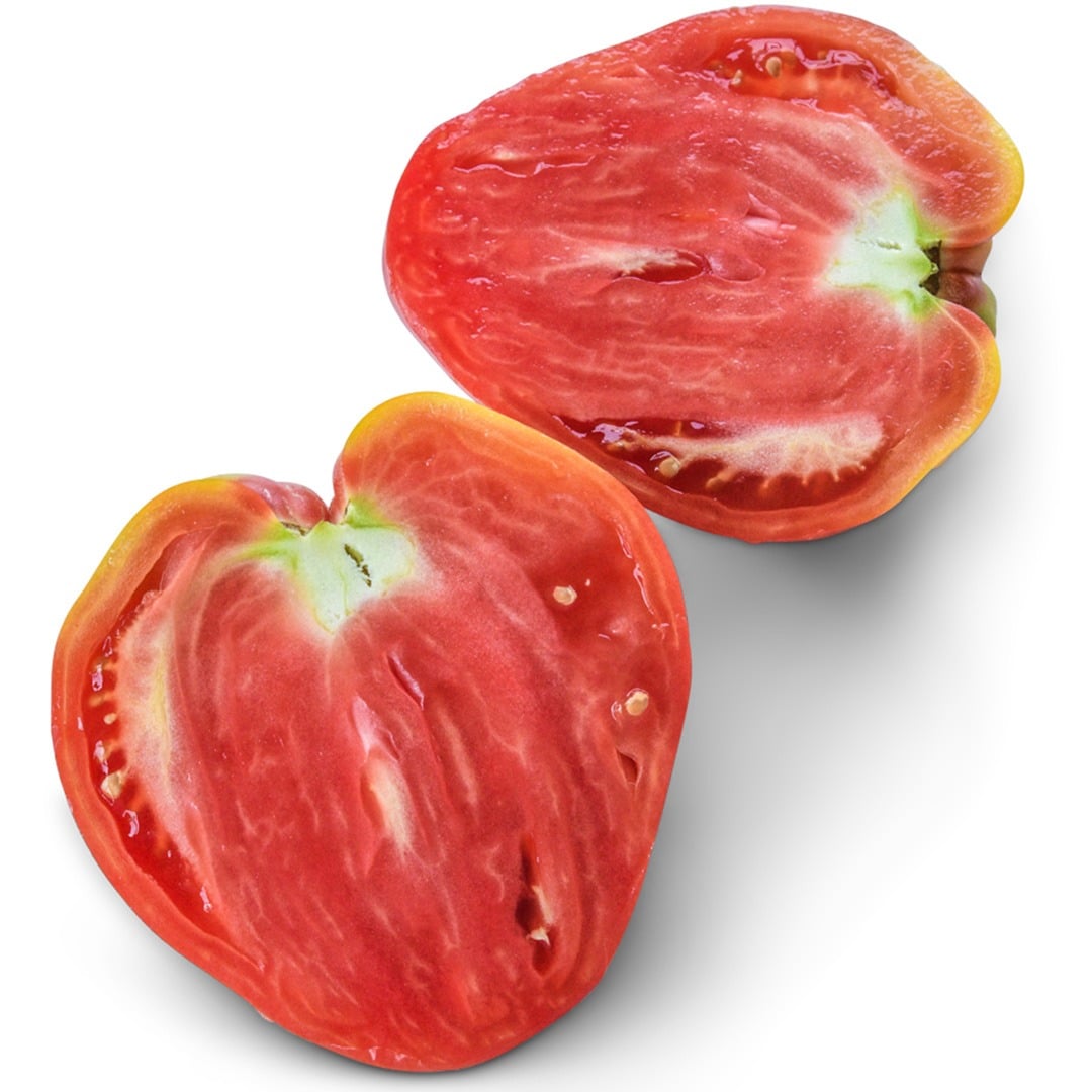 A Hungarian Heart Tomato sliced in half on a white background.