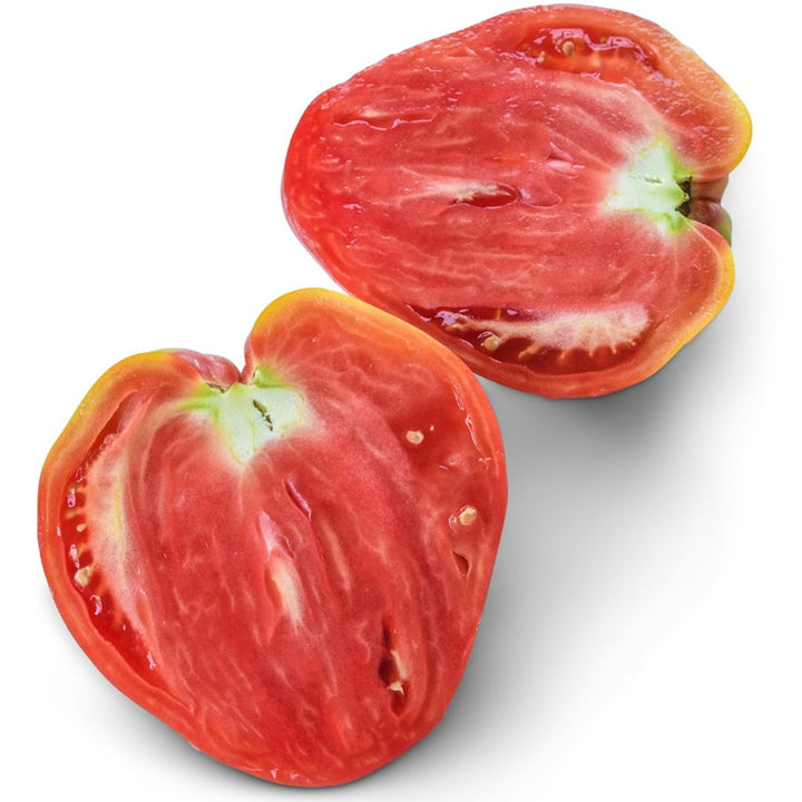 A Hungarian Heart Tomato sliced in half on a white background.