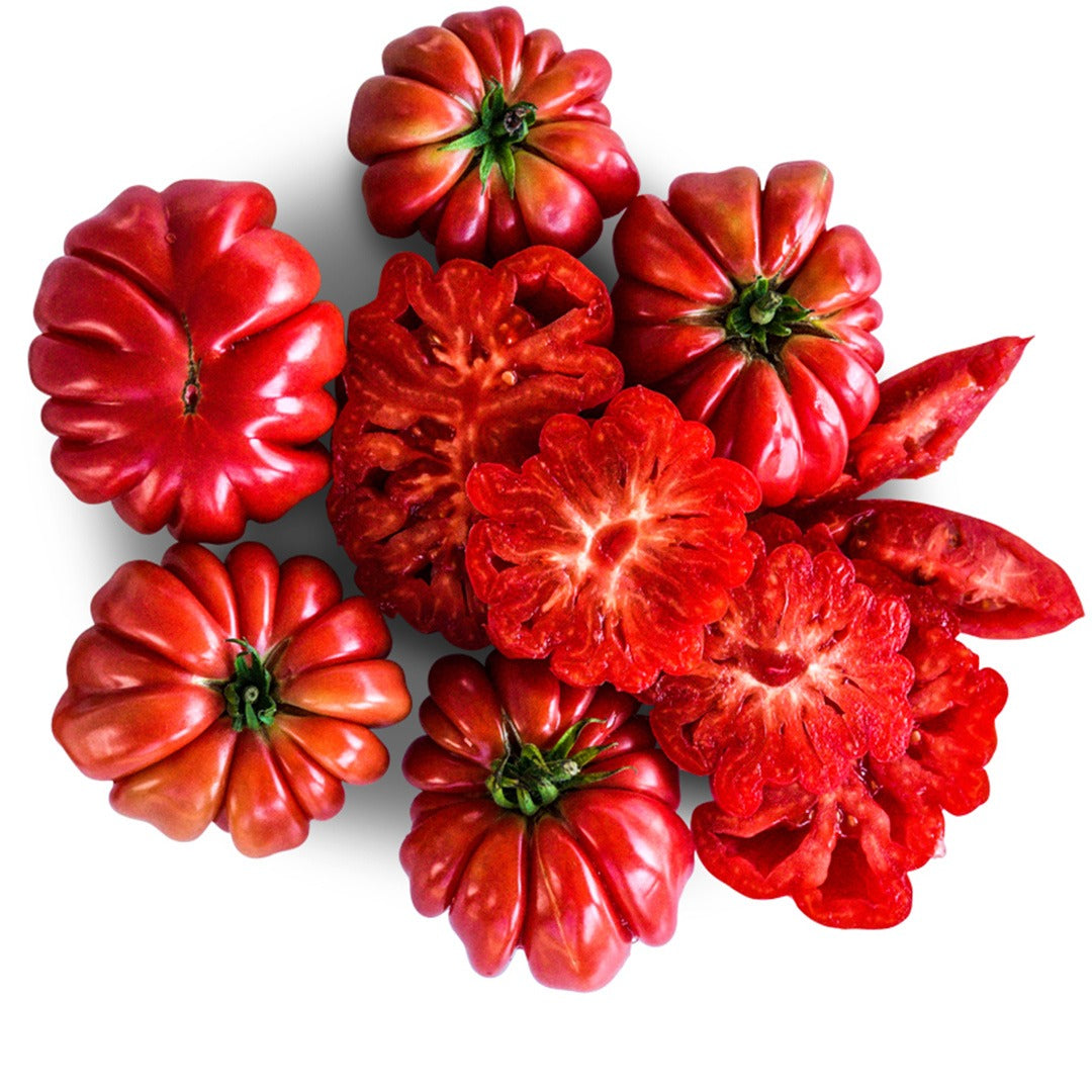 Whole and sliced Mushroom Basket Tomatoes on a white background.