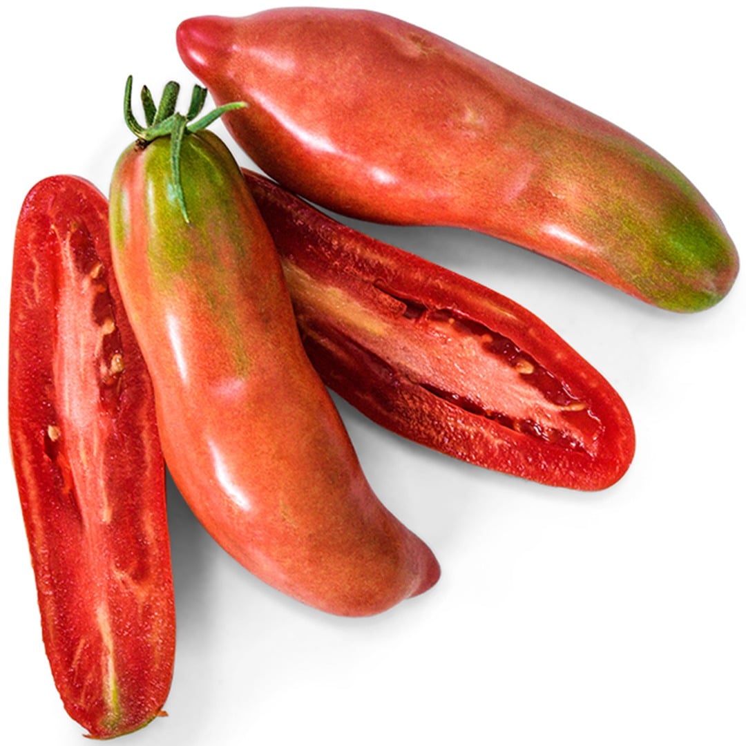 Whole and sliced Pink Fang Tomatoes on a white background.