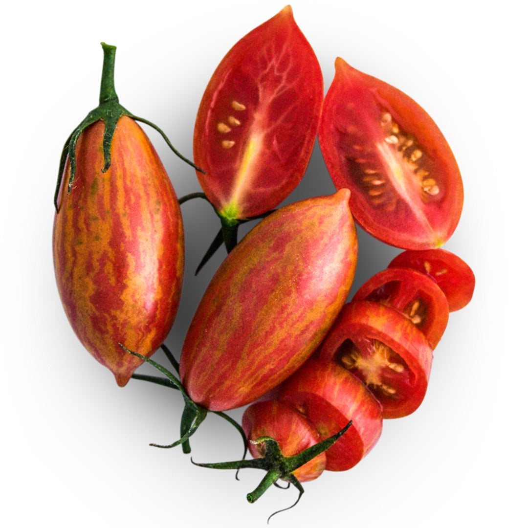 A couple whole and sliced Pink Tiger Tomatoes on a white background.