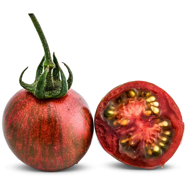A whole and sliced Purple Bumble Bee Tomato on a white background.
