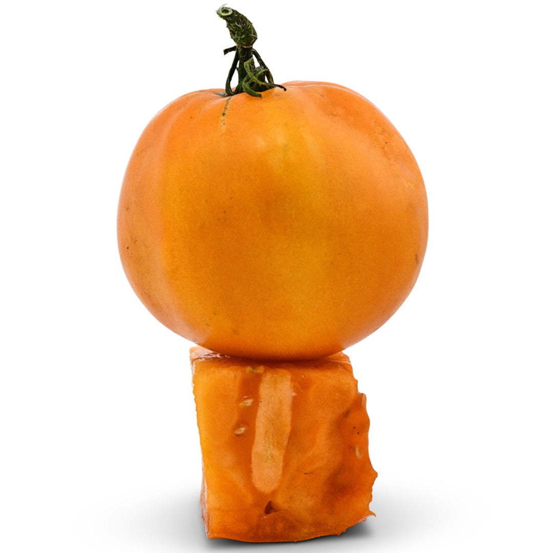 Whole and cut Woodle Orange Tomato stacked on a white background.