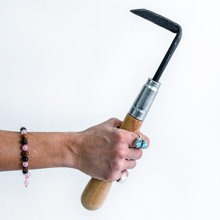 A woman's hand holding a Right Handed Cape Cod Weeder against a white background.