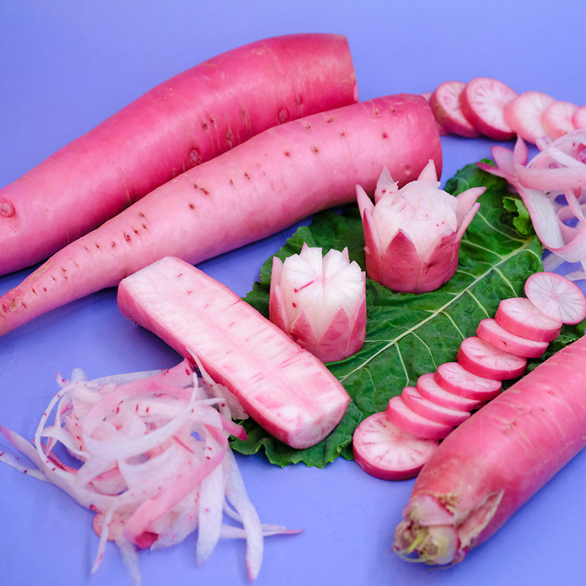 Pink Asuka Akane Turnips, carved as flowers and sliced on a lavender background.