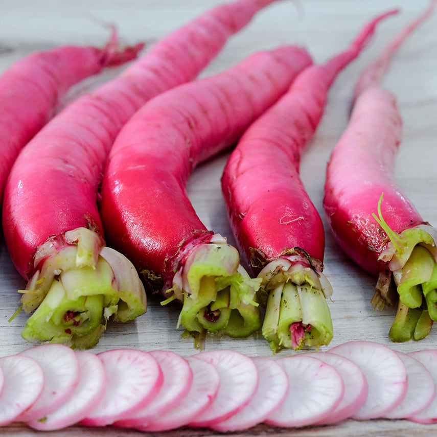 Asuka Akane Turnips lay in a row with slices on a light background.