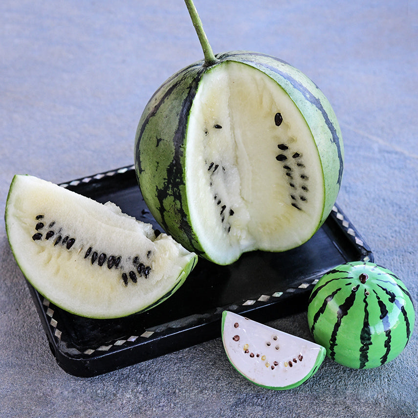 A cut Silver Yamato Watermelon on a Japanese tray with watermelon shaped salt and pepper shakers.