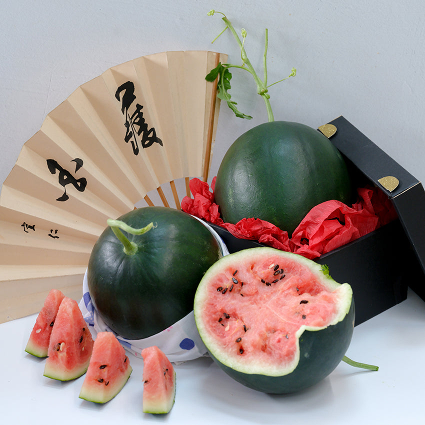 Black Jewel Watermelon, whole and halved with wedges and Oriental fan.