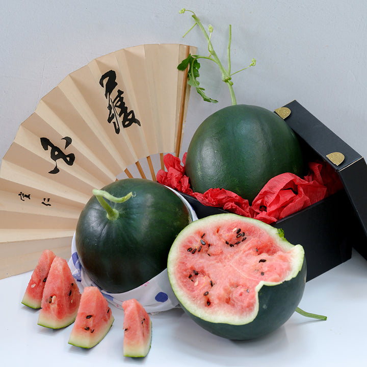 Black Jewel Watermelon, whole and halved with wedges and Oriental fan.