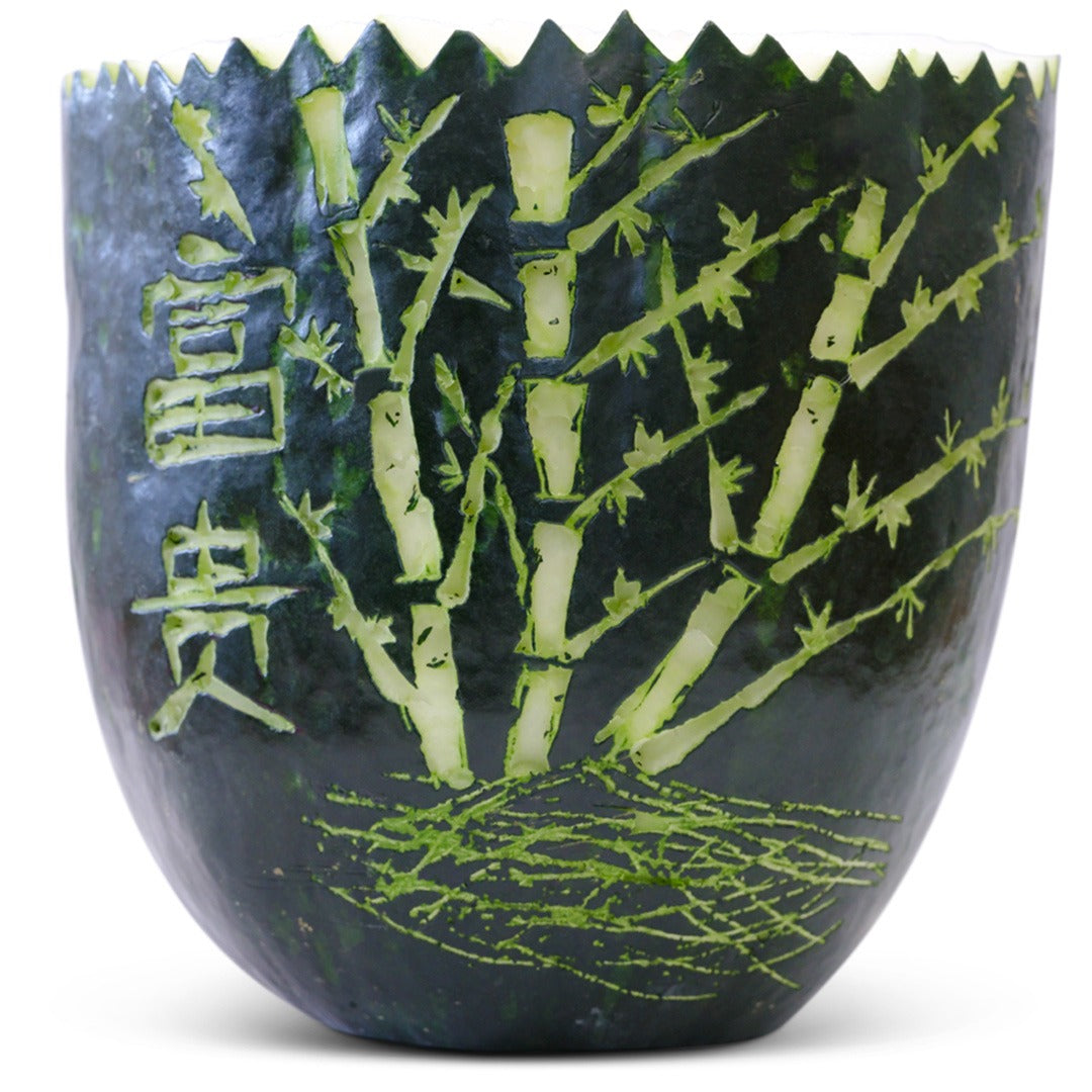 Wax Melon half with detailed bamboo carving on a white background.