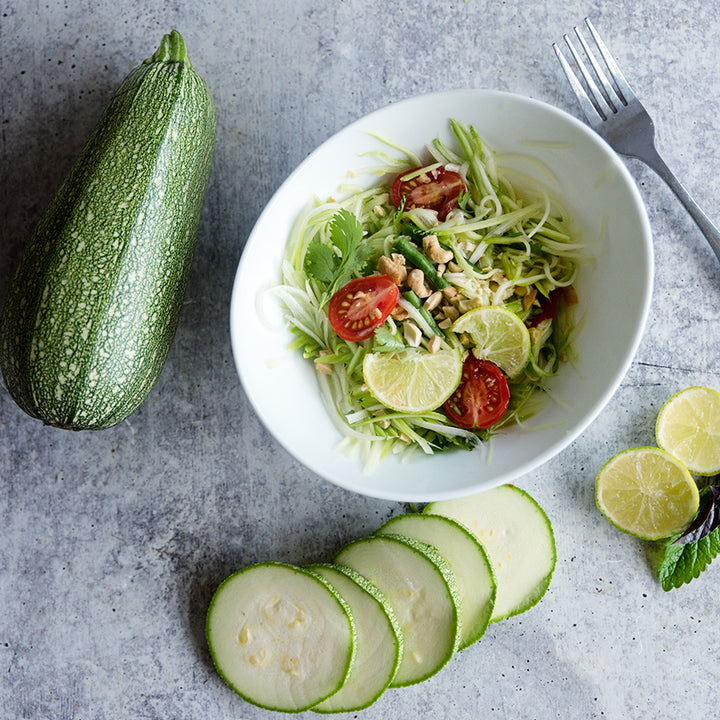 Gray Zucchini Summer Squash with shredded zucchini salad on gray background.