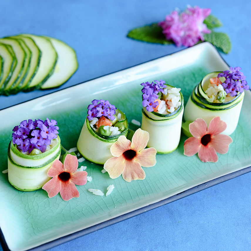 Nimba Zucchini Summer Squash vegetarian sushi with flowers on blue background.