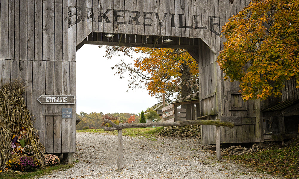 The weathered wooden Bakersville gate framing the village drive in autumn